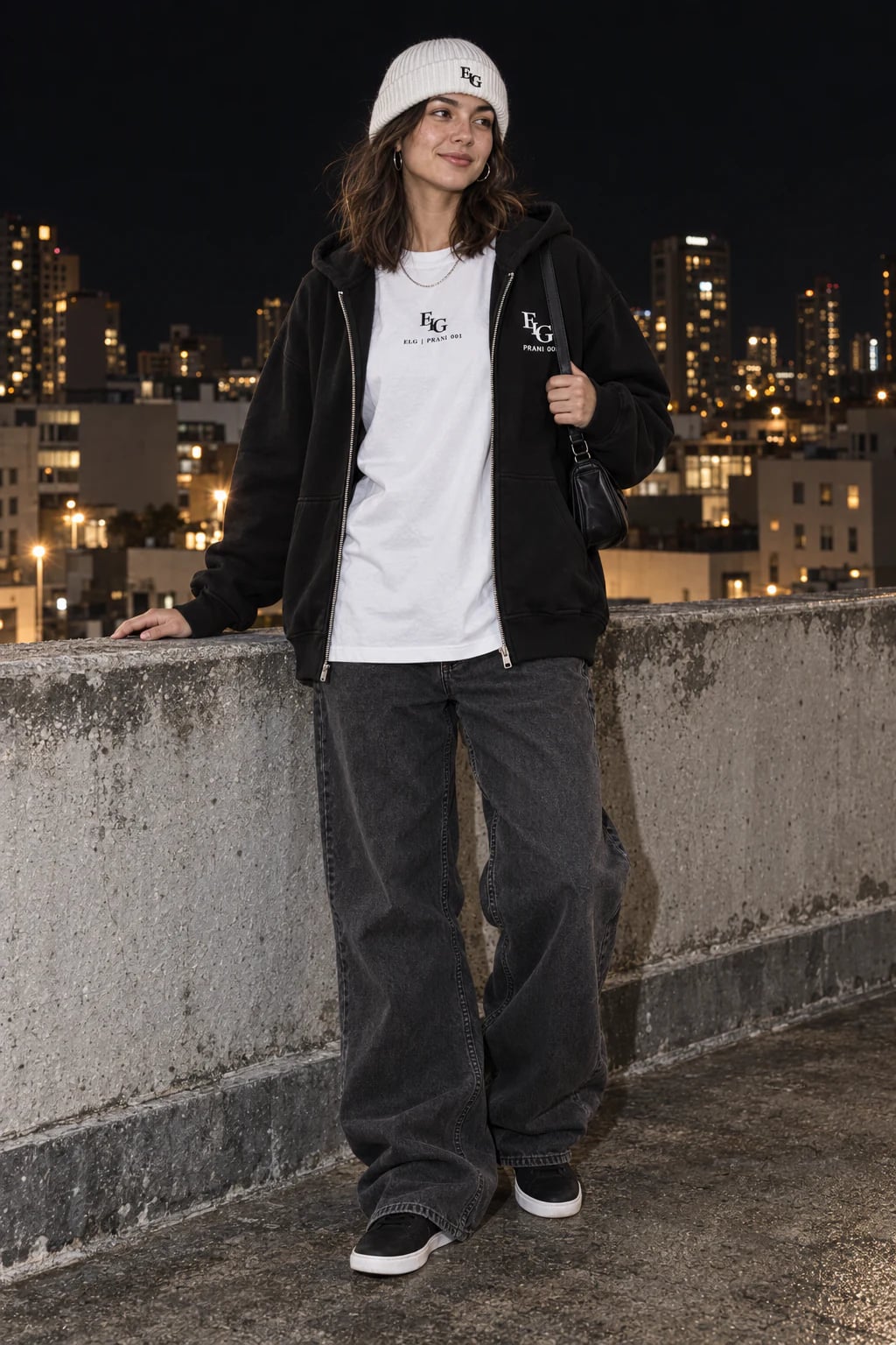 KI-Kampagnenbild einer jungen erwachsenen Frau mit selbstbewusster Haltung auf einer Dachterrasse bei Nacht, mit offenem schwarzem ELG-Zip-Hoodie, weißem T-Shirt über dem Hosenbund, weißer Beanie und verwaschen schwarzen Baggy-Jeans.